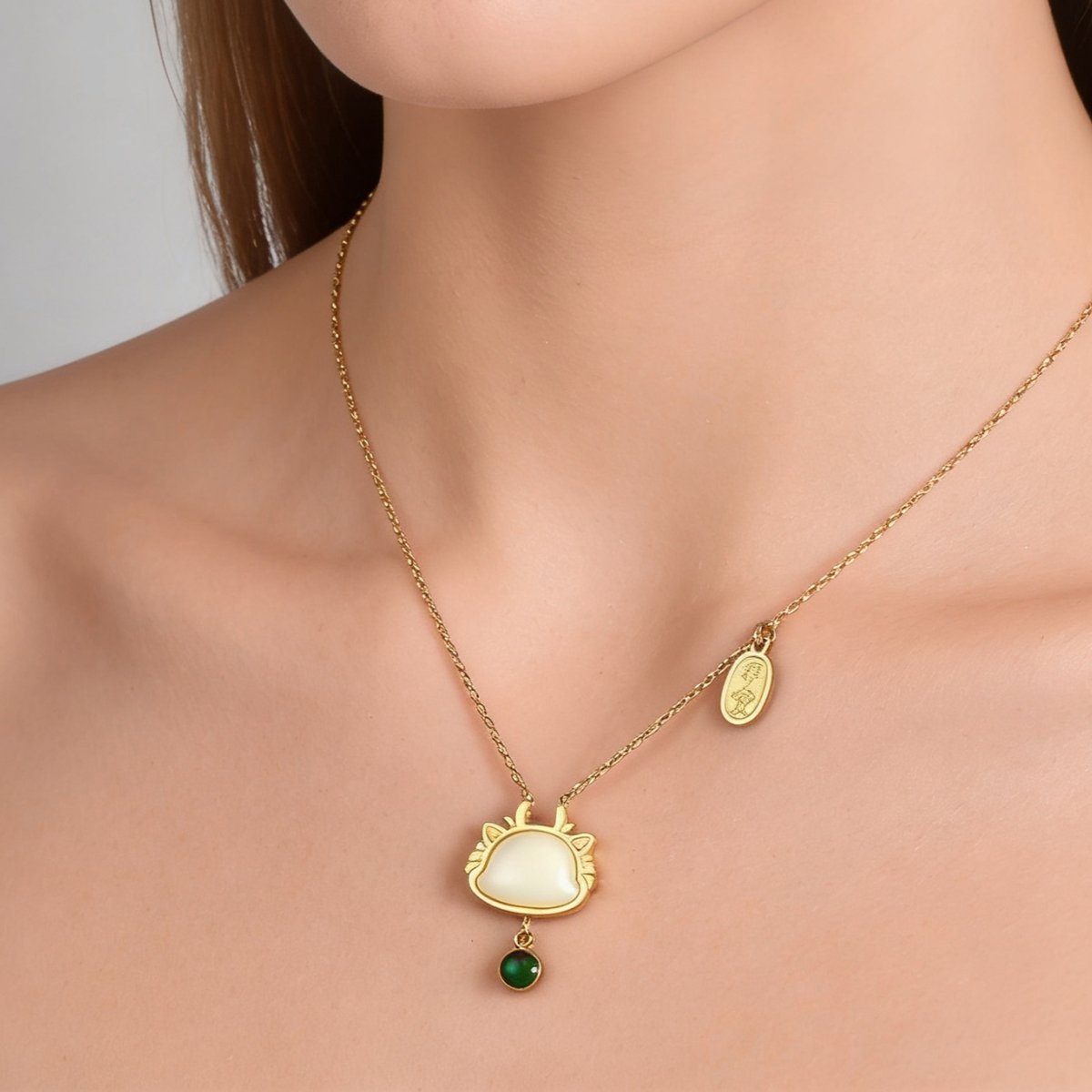Gold plated stainless steel beaded pendant necklace with cream pendant and green bead charm