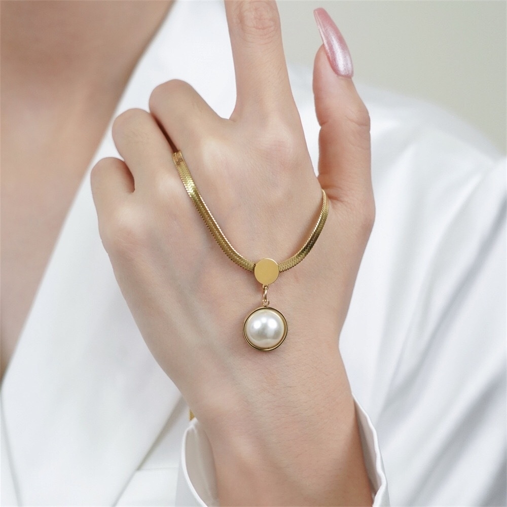 Pearl pendant snake chain necklace worn by a model
