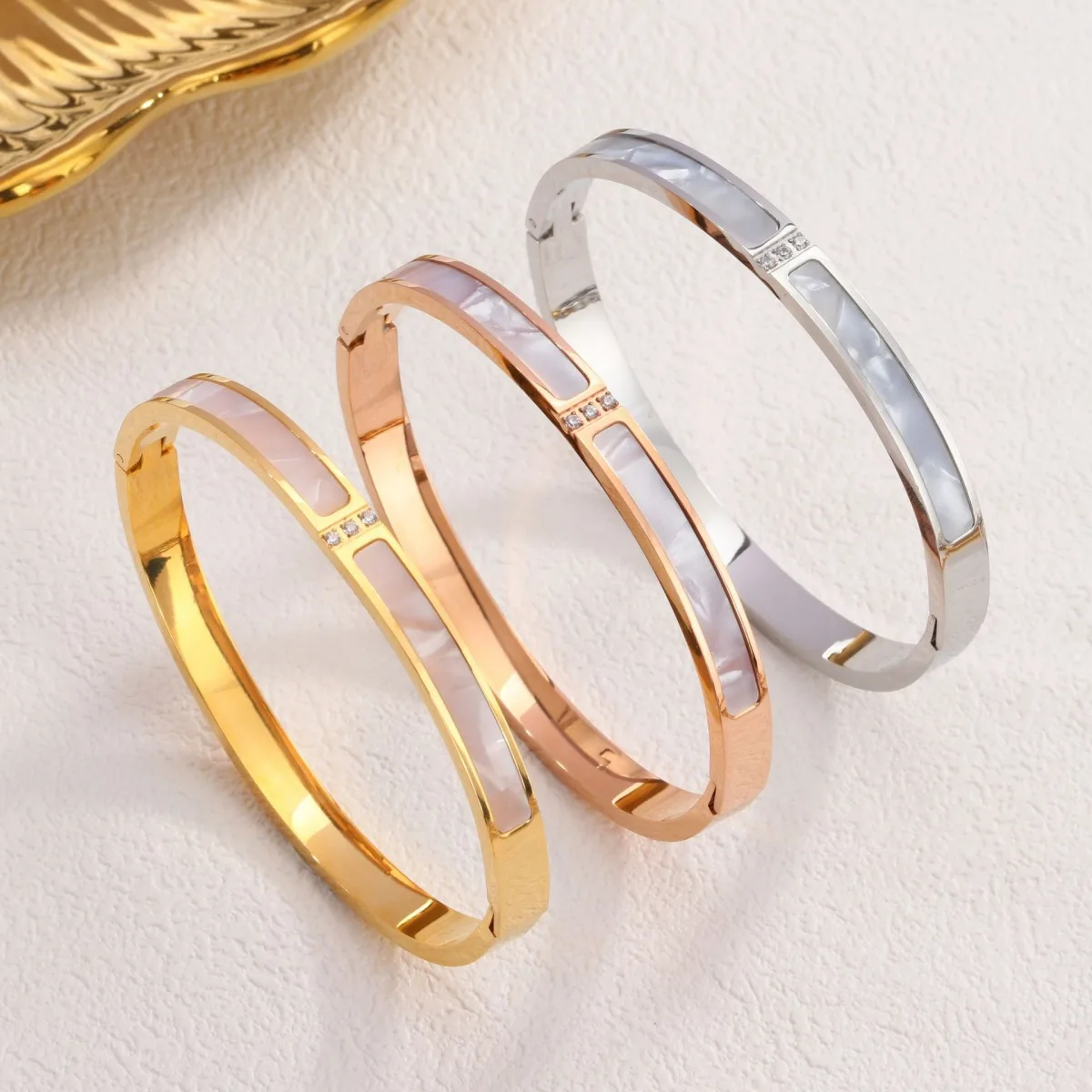 Gold stainless steel mother of pearl bangle on white background