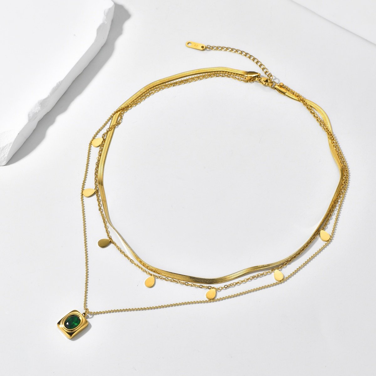 Gold plated layered green stone pendant necklace on white background