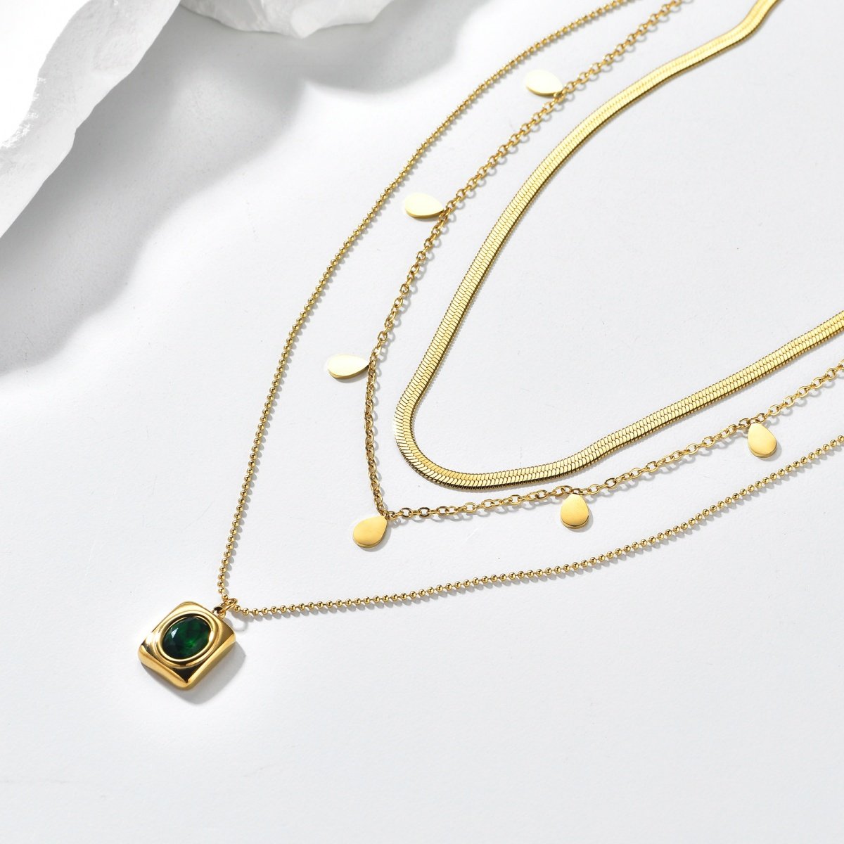 Gold plated layered green stone pendant necklace on white background
