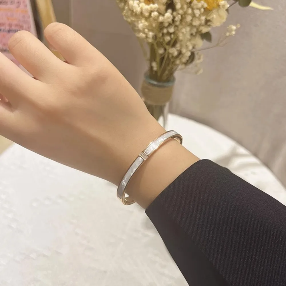 Gold stainless steel mother of pearl bangle on white background