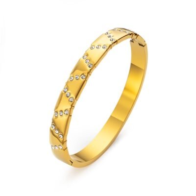 Gold stainless steel crystal bangle on white background