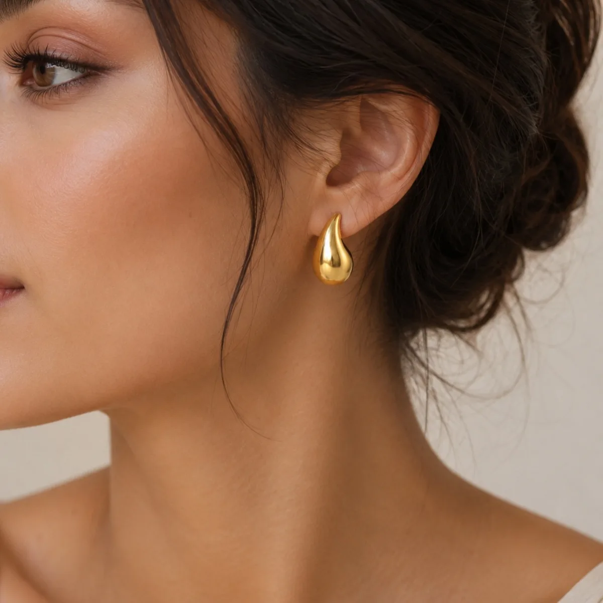 gold teardrop stud earrings on white background