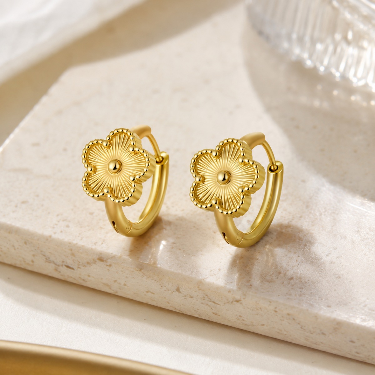 gold flower hoop earrings on white background