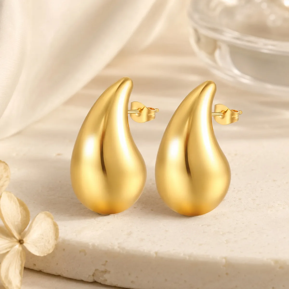 gold teardrop stud earrings on white background