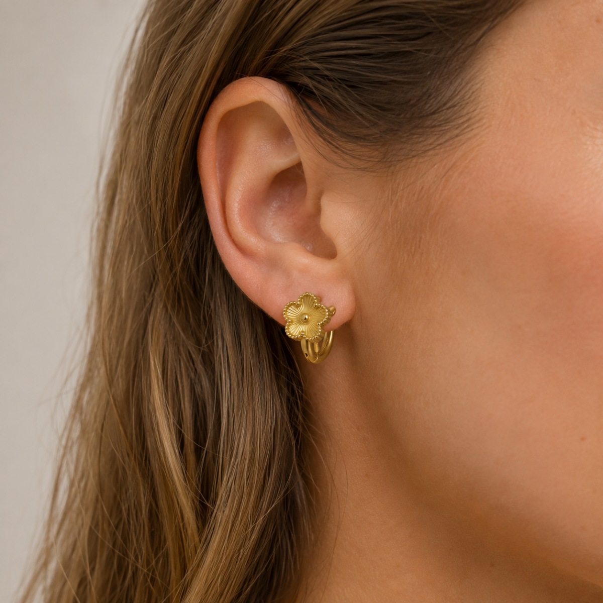 gold flower hoop earrings on white background
